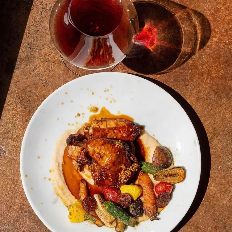 Un platillo colorido junto a una copa de vino en Grand Cru, uno de los mejores restaurantes en Monterrey.