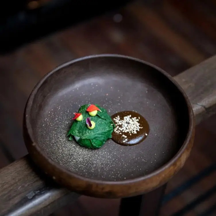 Un plato con una porción de mole y vegetales en Sud 777, de las mejores opciones de cocina nacional en CDMX.