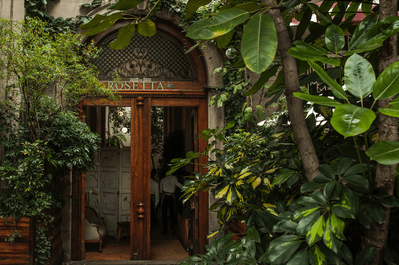 La entrada al restaurante se hace por un portón de madera rematado en arco, propia de una casona Porfiriana.