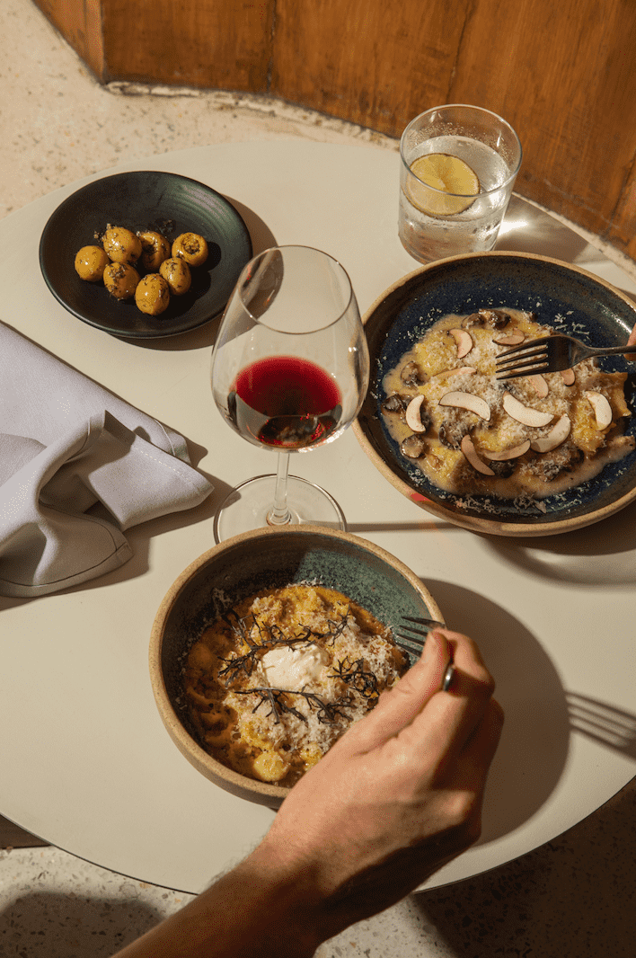 Platillos de pasta, una copa de vino y un coctel del restaurante Meroma