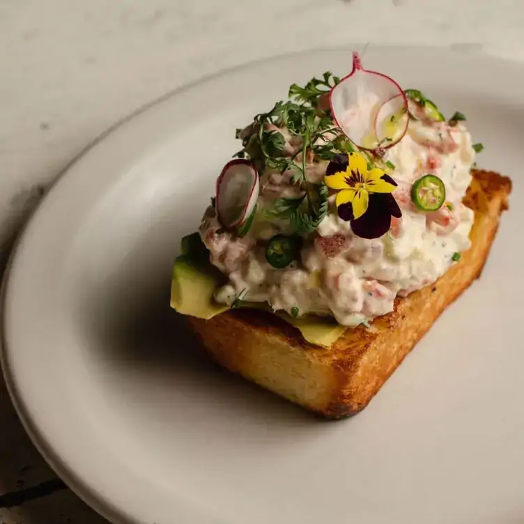 Platillo francés con flores en Havre 77, uno de los mejores restaurantes en la CDMX para comer al aire libre.