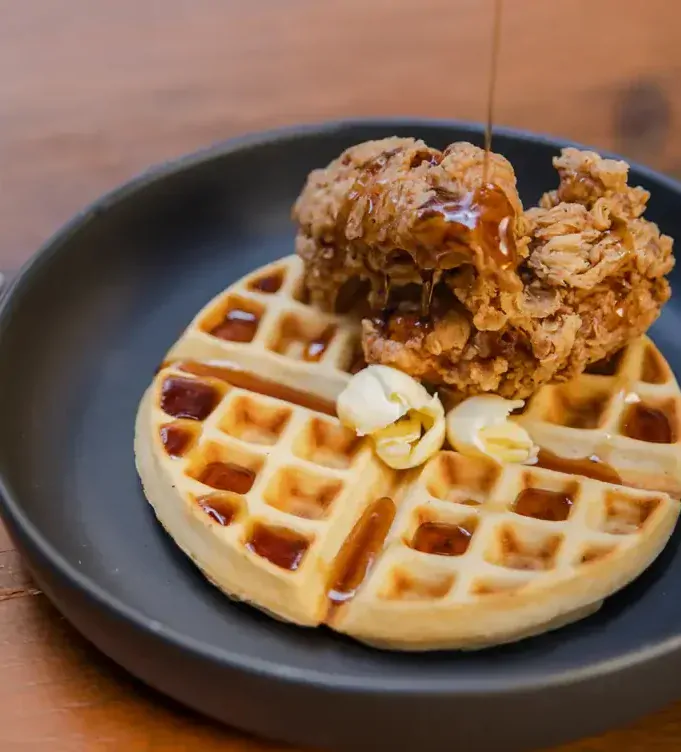 Waffles acompañados de pollo frito en Petit Roquefort, uno de los mejores restaurantes para desayunar en la CDMX