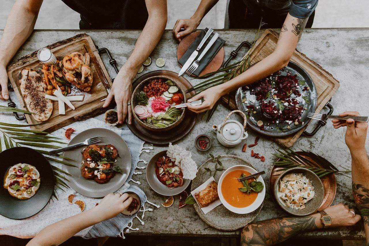 Gente disfrutando de una mesa llena de platillos con vegetales del huerto en Acre.