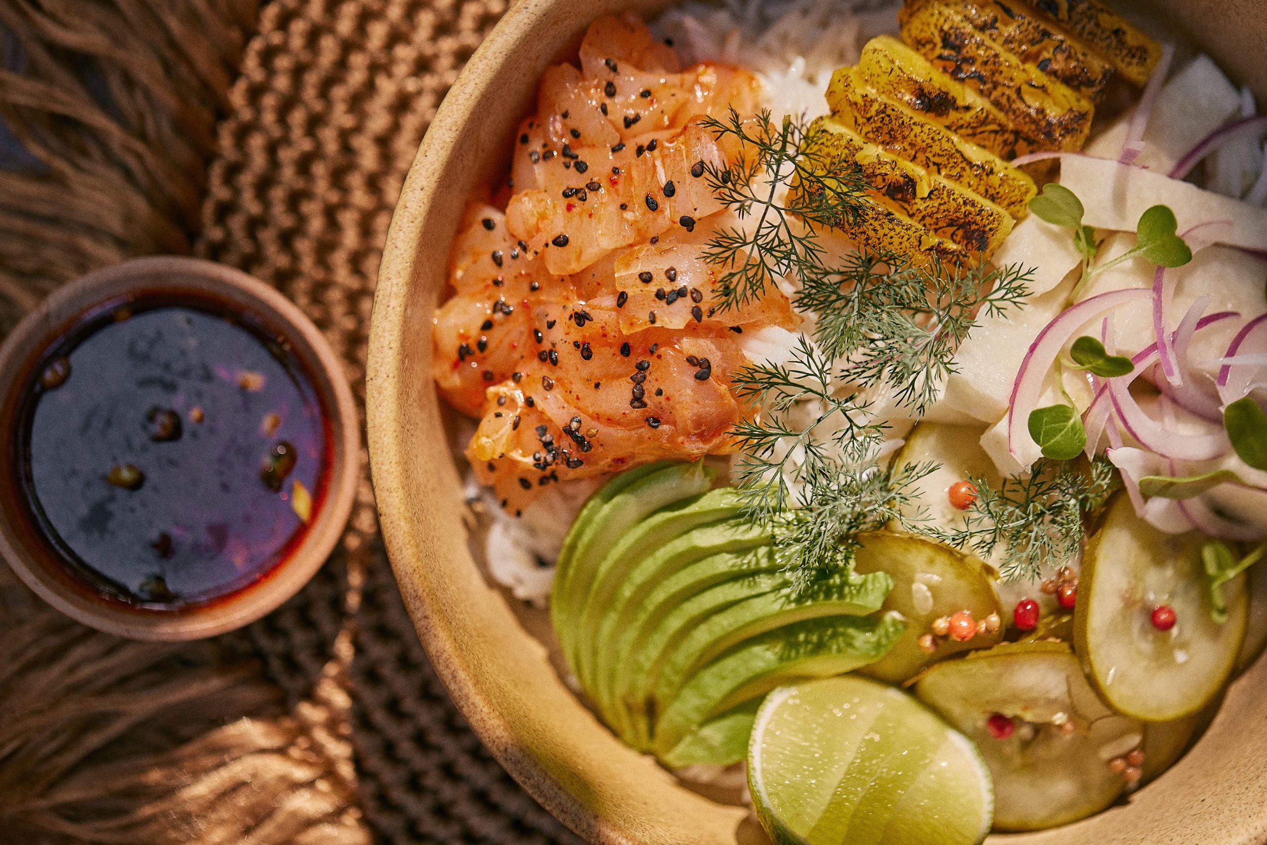 Bowl con salmón, piña, arroz, aguacate y pepinillos encuartidos de Moro en Habitas Tulum.