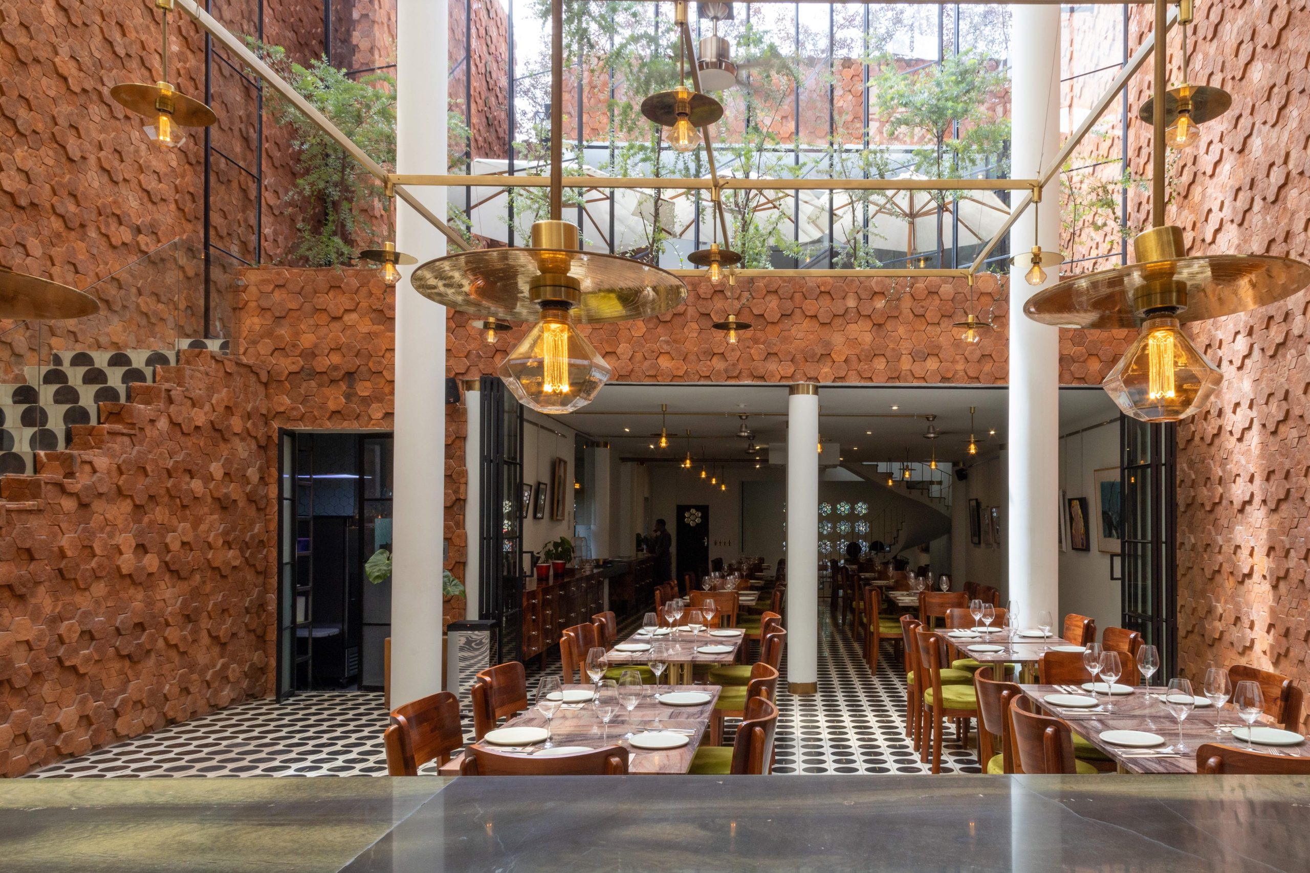 Interior del restaurante Octo, en Guadalajara, con techos de doble altura y grandes ventanales.