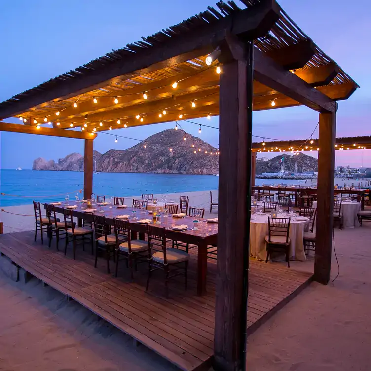 Una mesa en la playa en Hacienda Cocina y Cantina