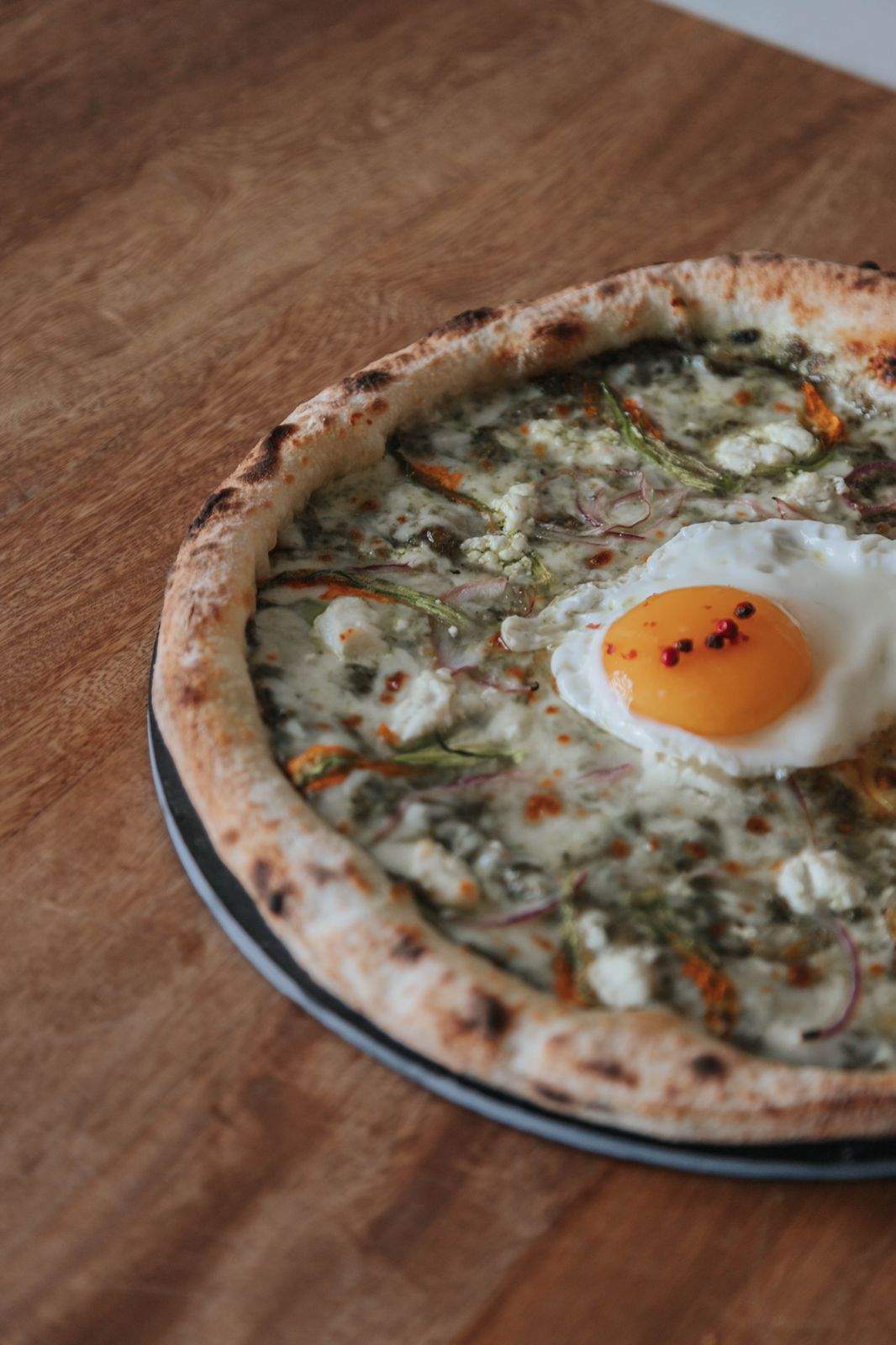 Pizza Dos, preparada con pesto, flor de calabaza, cebolla morada, queso de cabra y pimienta, en el restaurante Rupestre en Guadalajara.