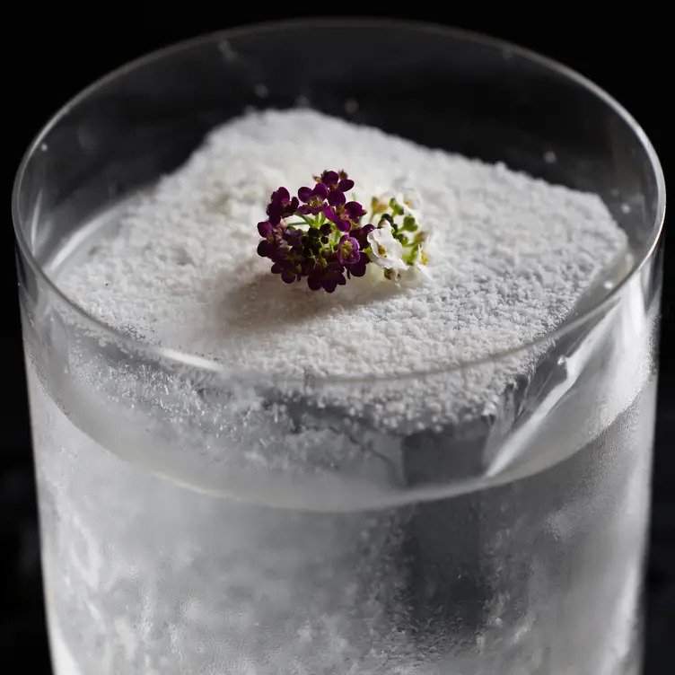 Vaso de cristal con un hielo gigante con polvo de chocolate blanco encima