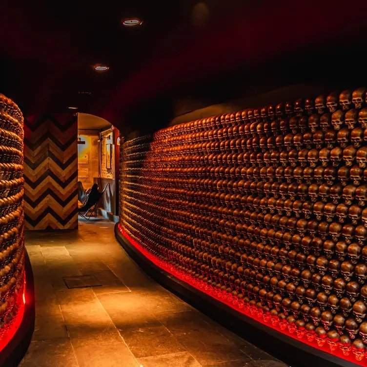 Túnel decorado con muros llenos de esculturas en forma de calaveras en el interior del restaurante Gin Gin Polanco, en la Ciudad de México.