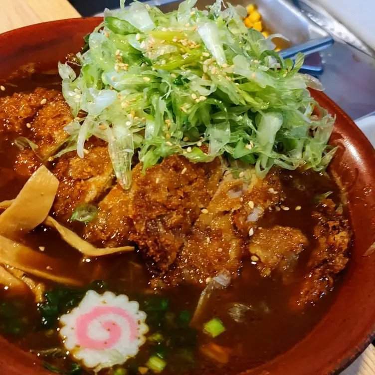 Ramen japonés servido en un plato rojo en el restaurante Yamasan Ramen House, uno de los mejores restaurantes baratos de CDMX.