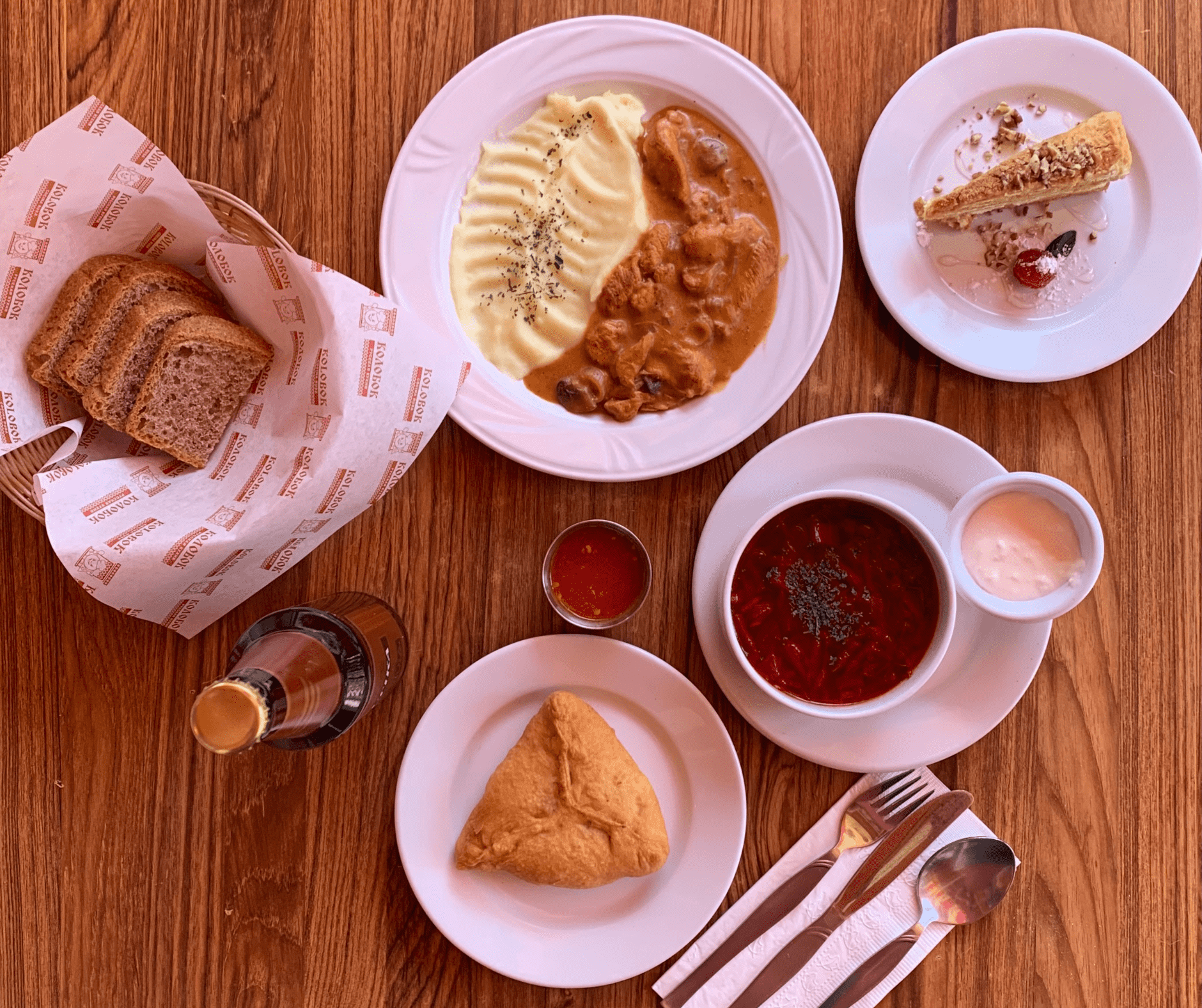 Mesa de madera con platos tradicionales rusos en Kolobok, uno de los mejores restaurantes baratos de CDMX.