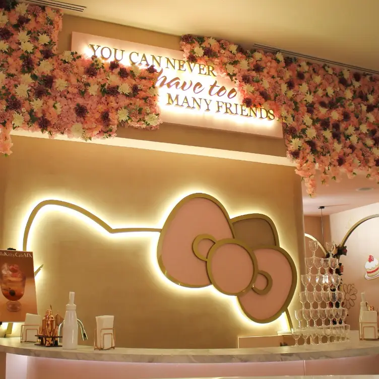 Interior de Hello Kitty Café Cháteau, uno de los mejores restaurantes para desayunar en CDMX, el cual muestra una fachada de piedra decorada con ventanas rosas y el nombre del lugar con el característico moño de Hello Kitty