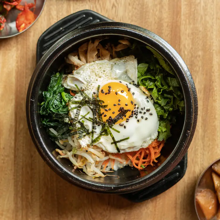 Hecho de arroz frito, verduras, salsa picante y un huevo estrellado, el bibimbap es de las opciones más demandadas en Midam, uno de los mejores restaurantes en CDMX de cocina coreana.