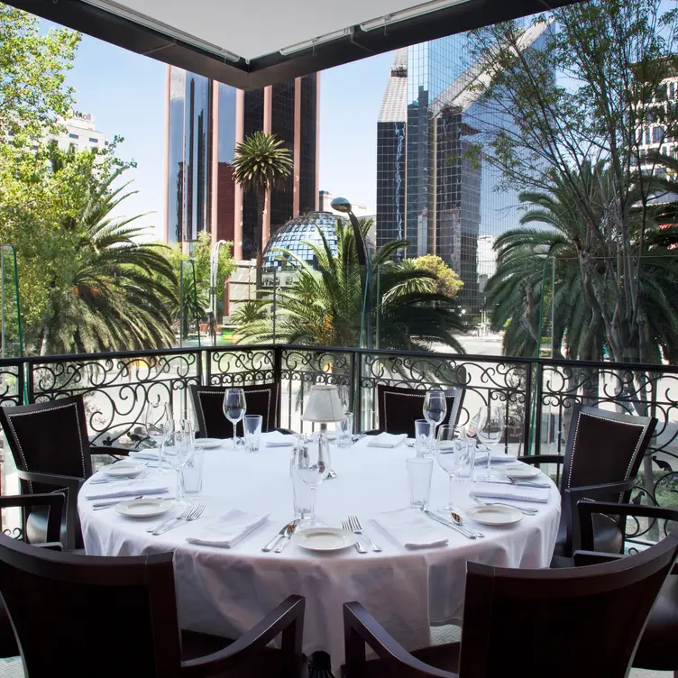 Una terraza en The Capital Grille con una vista exterior a los edificios de CDMX.