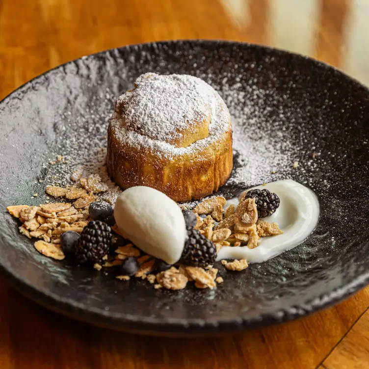 Un platillo de Balta, uno de los mejores restaurantes para desayunar en CDMX, que incluye un pan con azúcar glass, zarzamoras y granola