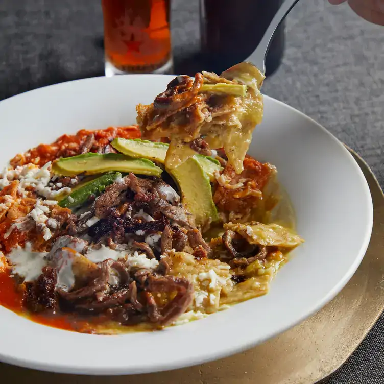 Unos chilaquiles campechanos con cecina en Carolo Carso, uno de los mejores restaurantes para la cena de navidad en la CDMX.