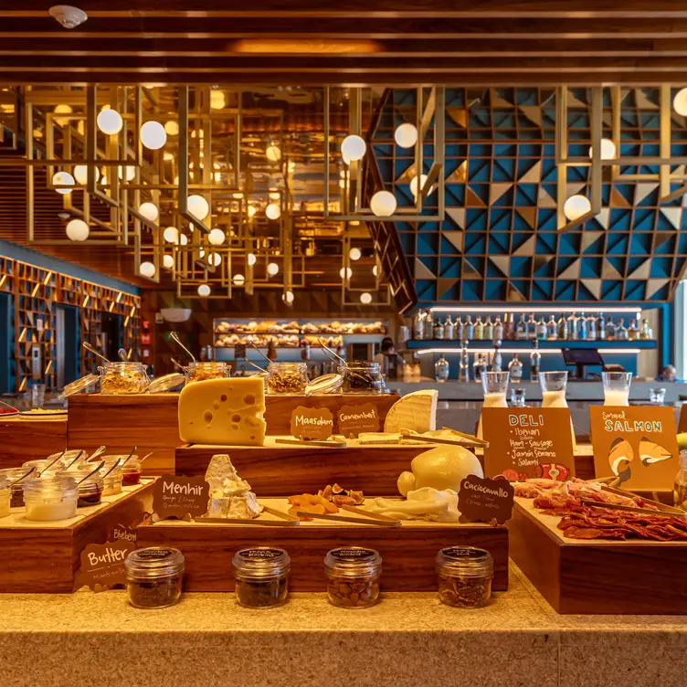 Interior del restaurante Balta en el que se muestra una buffet de desayuno con quesos, salmón y carnes frías