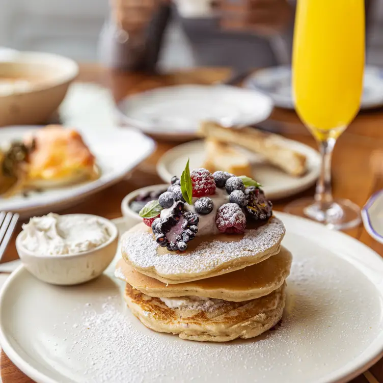 Un plato de hot cakes con frutos rojos ofrecido en Balta, uno de los mejores restaurantes para desayunar en CDMX.