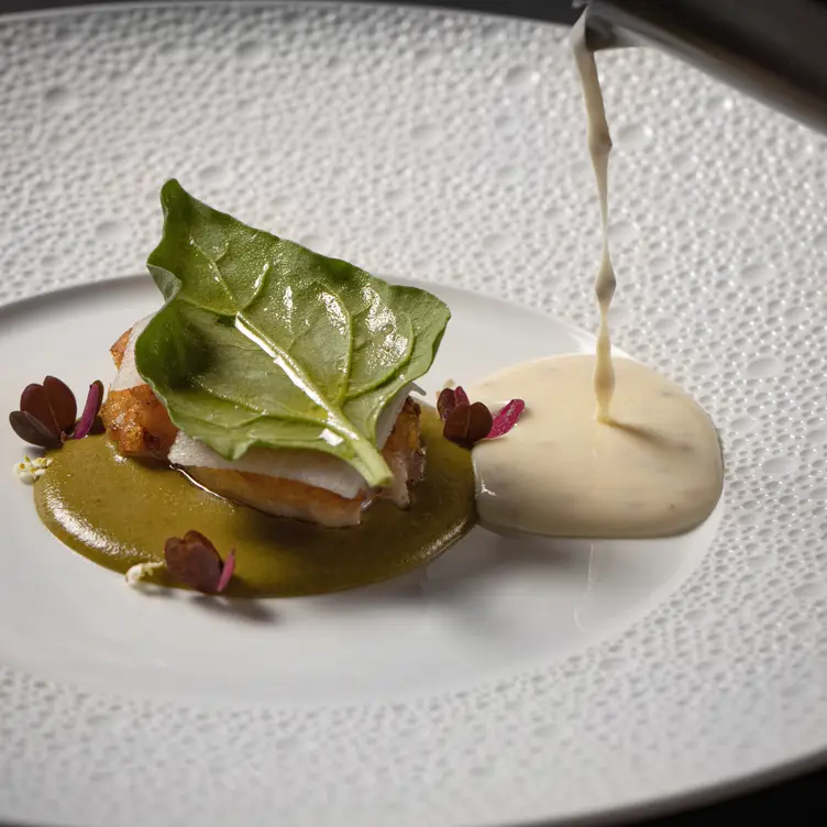 Un plato para degustar con algunas hierbas y crema en Koli Cocina de Origen, una de las mejores opciones en Monterrey para probar la cocina del noreste