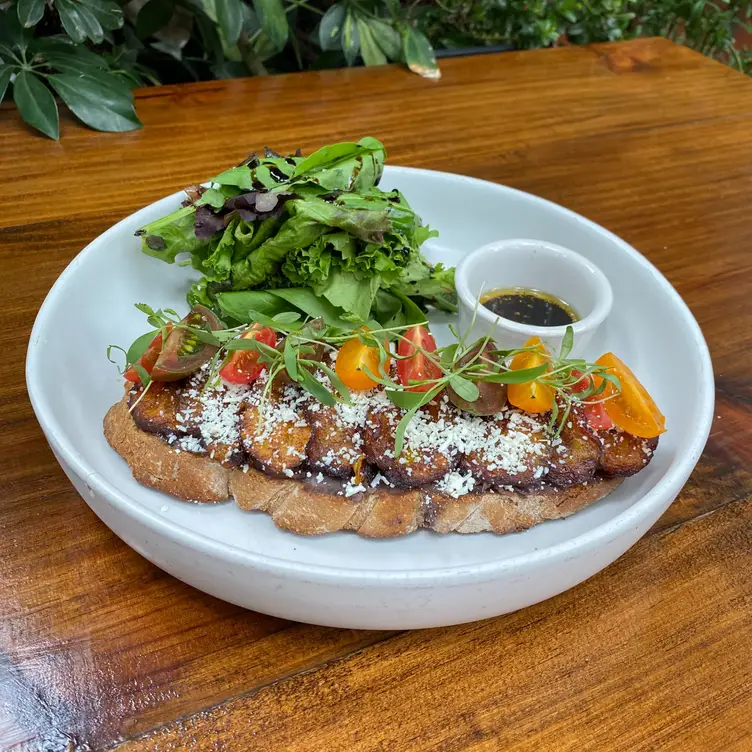 Un plato con pan tostado y diversas verduras en Petit Roquefort.