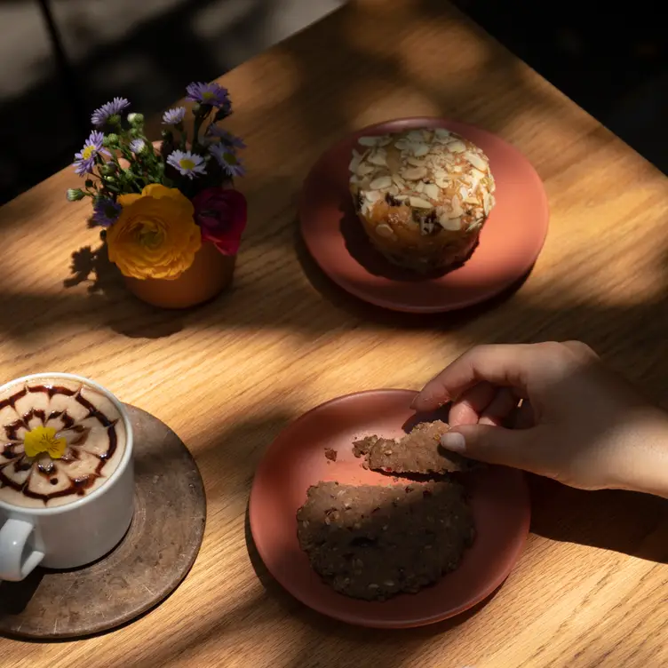 Una bebida caliente, una galleta y un muffin en Vegamo.