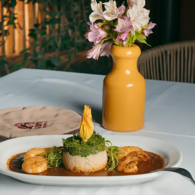 Un plato con camarones en adobo y arroz, al lado de tortillas y un florero en La Noria, uno de los mejores restaurantes románticos en Puebla.