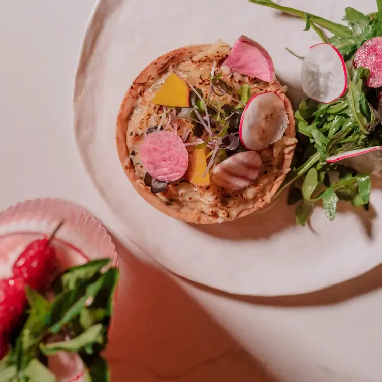 Un plato con una tostada y vegetales en Delina Rooftop, uno de los mejores restaurantes en Mérida.