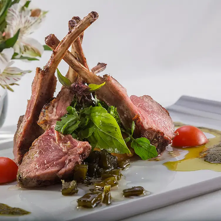 Pedazos de costilla a la parrilla, acompañados con nopales, jitomate y otros vegetales.