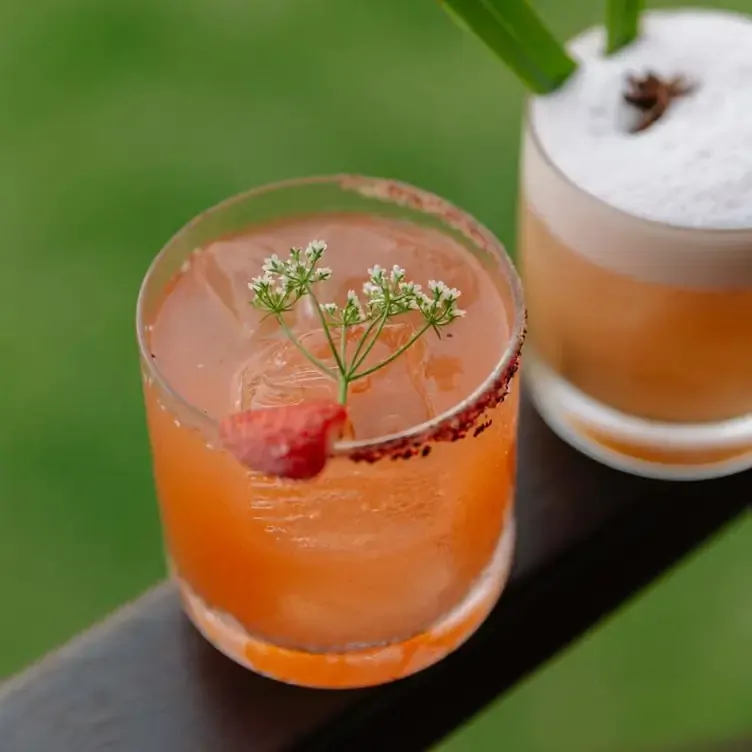 Un coctel preparado en Ixi'im, finamente decorado con fruta, pequeñas flores y el vaso escarchado con chile y sal.