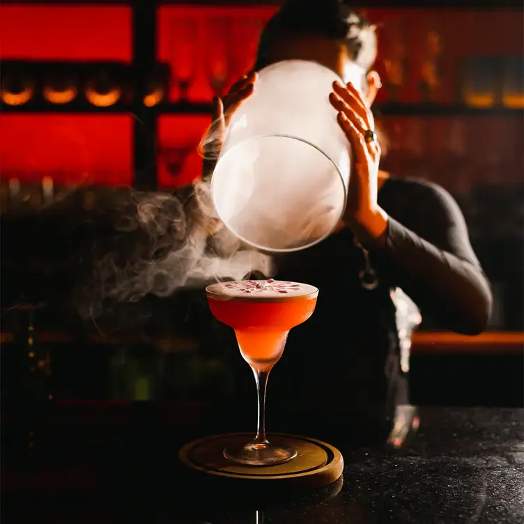 Un bartender dando el último toque a un coctel especial de la casa en Flamel