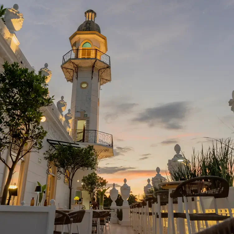 Vista de Delina Rooftop, la parte alta de un antiguo edificio de color blanco como las mesas y sillas en tonos cafés.