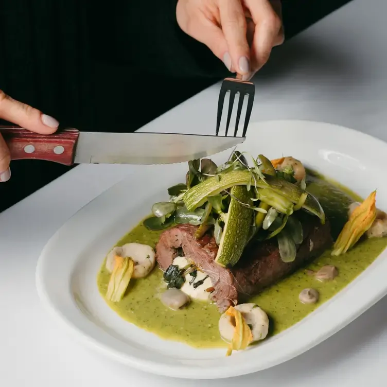 Un platillo de carne, salsa verde y vegetales en La Noria, un restaurante ubicado en una antigua hacienda poblana.