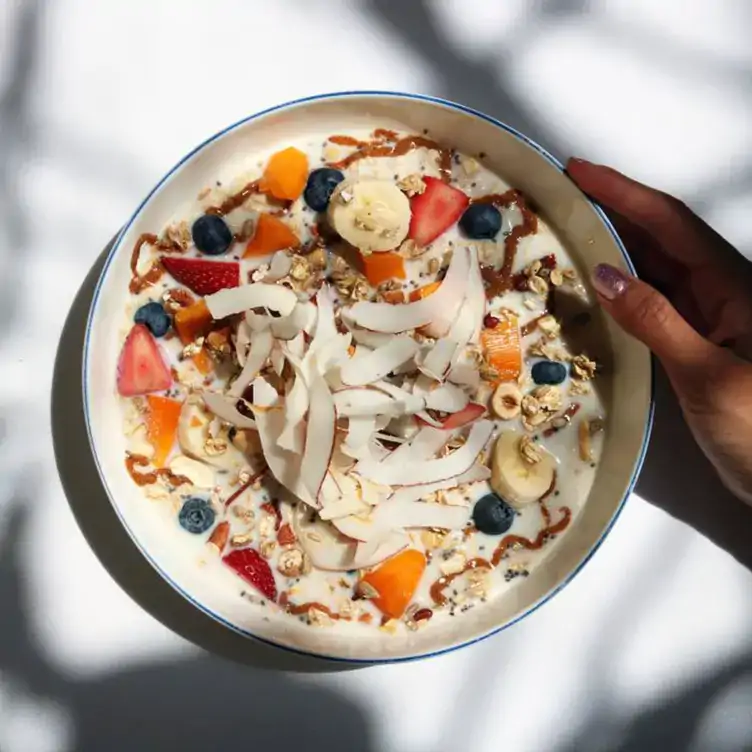 Un bowl de fruta con granola, coco y miel en Mandolina, uno de los mejores restaurantes para el brunch en la CDMX.