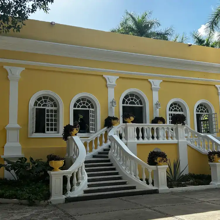 Fachada de color amarillo pastel con blanco en la casa colonial que alberga a Hacienda Teya, de los mejores restaurantes románticos que hay en Mérida.