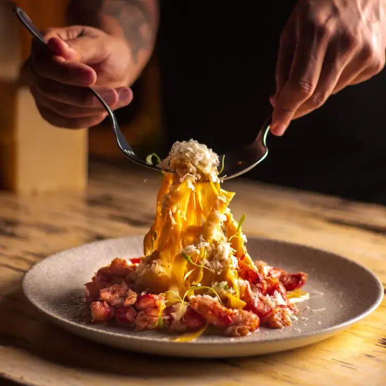 Un plato de pasta siendo recogida con cubiertos en Parole Polanco, una de las mejores opciones para comer en CDMX.