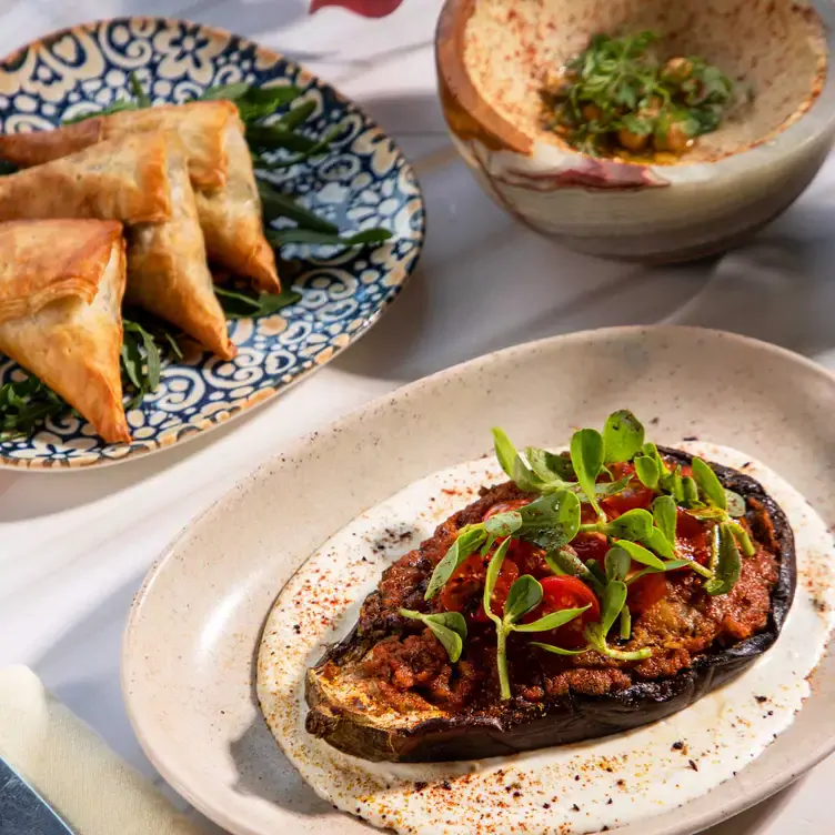 Rellena de pasas, almendras, coliflor, tomate y especias, la berenjena asada está entre las entradas más pedidas en Ilios, uno de los mejores restaurantes en Cancún.