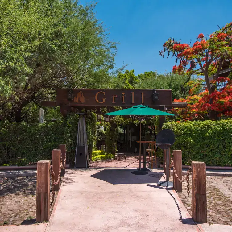 La entrada a Restaurante Emilia, uno de los mejores brunch en Querétaro, con un espacio para mesas rodeadas de vegetación.