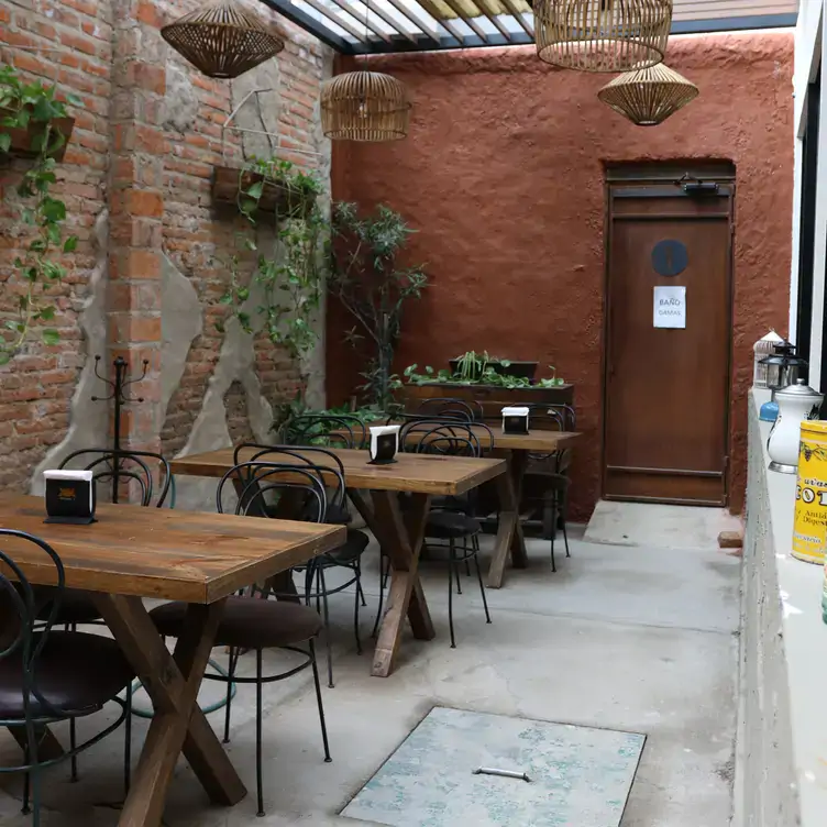 Vista del interior hacia las mesas de madera y herrería, así como muros de ladrillo en Pulpería, de las mejores opciones para el brunch en Guadalajara.