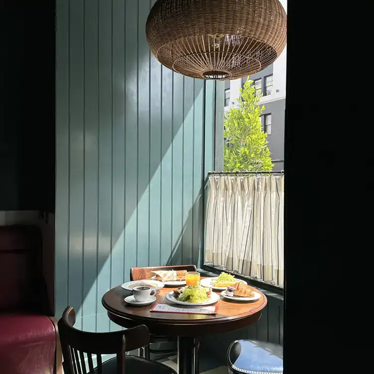 Una vista a una mesa iluminada junto a la ventana en Saint James French Diner.