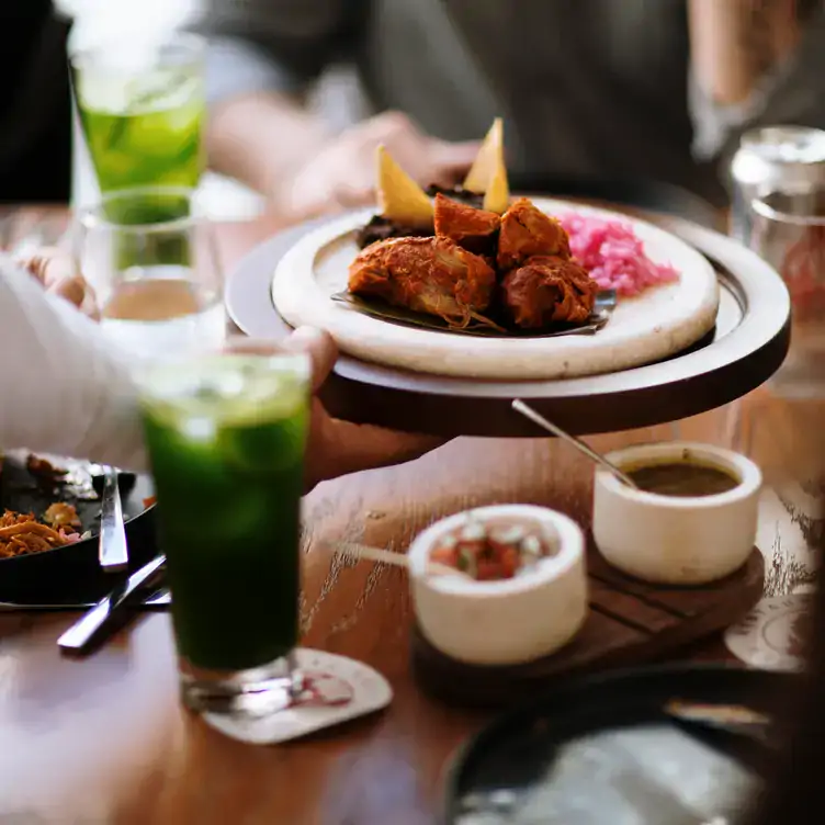 Una mesa servida con platillos tradicionales y aguas en TEYA - Gastronomía Yucateca Viva, de los mejores lugares para el brunch en Mérida.