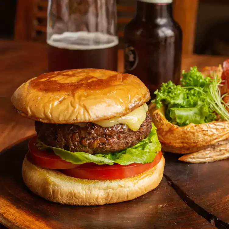 Una mesa con una hamburguesa y una cerveza en Chooj Galería Gastronómica, uno de los mejores lugares para desayunar en Mérida.