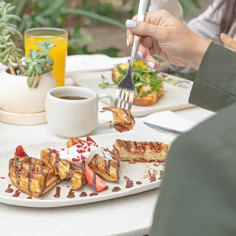 Los waffles preparados con masa madre y cubiertos de varias salsas dulces de Tierra X OUM