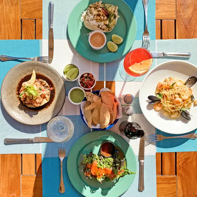 Una selección de platillos del mar con totopos y salsas al centro en Caribeño Cancún.