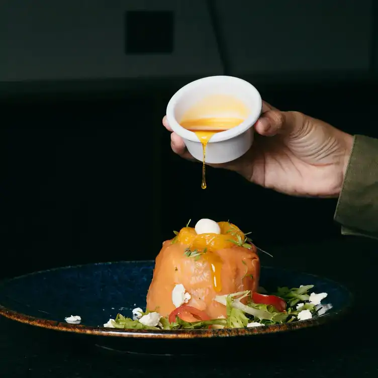 Ensalada de salmón acompañada con queso de cabra y una vinagreta de mandarina y chipotle en La Noria, uno de los mejores restaurantes para desayunar en Puebla.