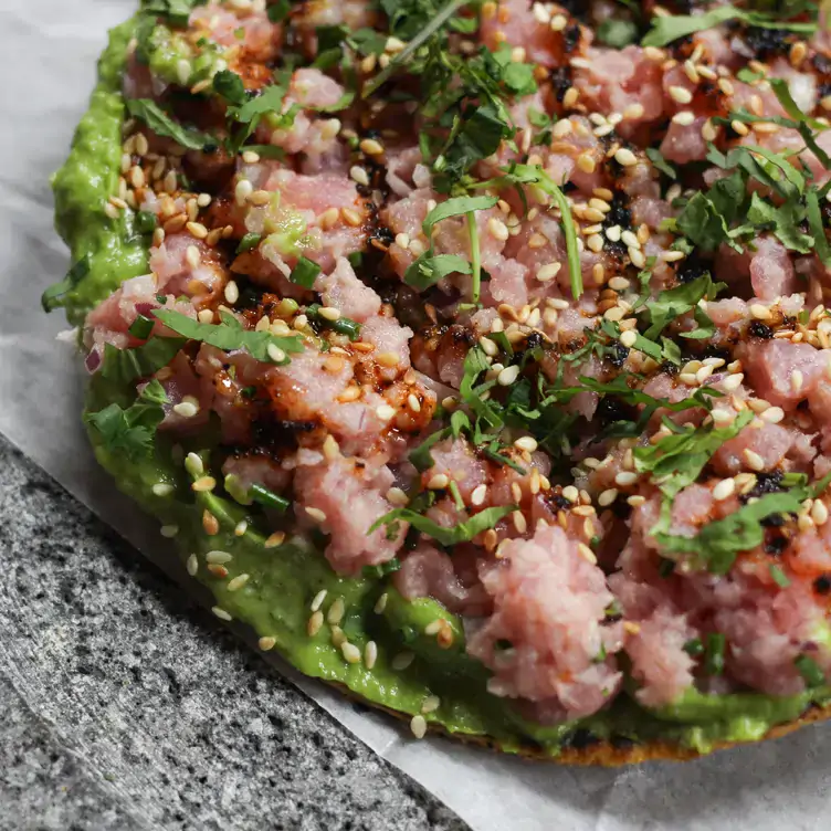 Una tostada de atún sobre una cama de aguacate te espera en Embajadora.