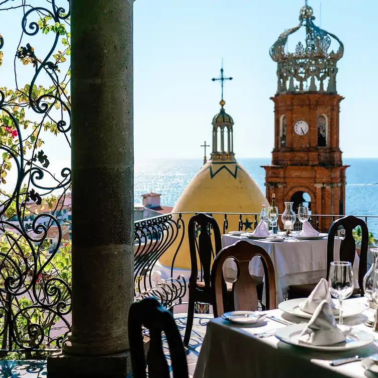 Vista desde la terraza de La Cappella, con panorámica al templo de Guadalupe de Puerto Vallarta y el mar al fondo.