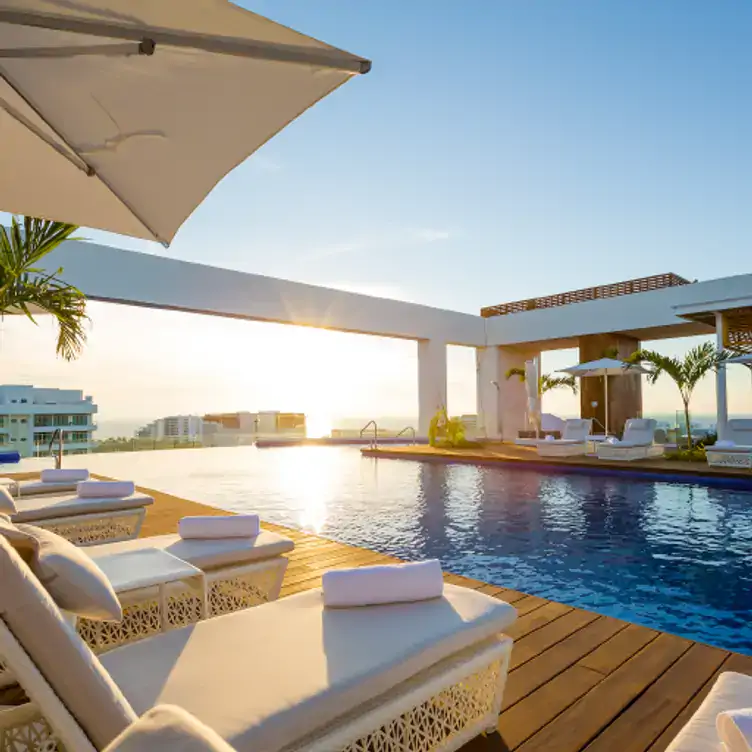 Vista de la piscina y sillones reclinables en el Quinto at Vidanta Nuevo Vallarta, de los mejores restaurantes de carnes en Puerto Vallarta.