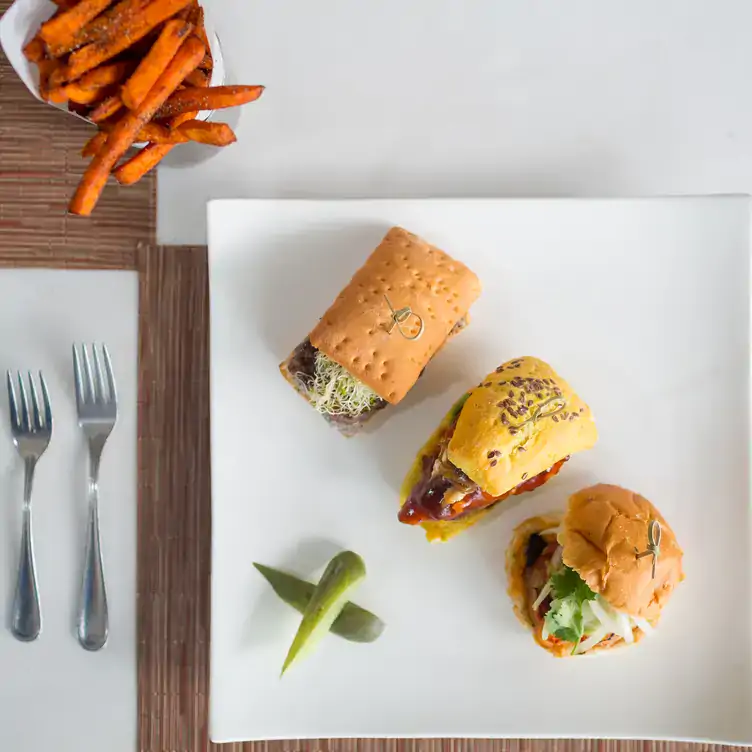 Un plato con una hamburguesa, dos sándwiches y papas en Burger at Vidanta Vallarta, uno de los mejores restaurantes en Puerto Vallarta.