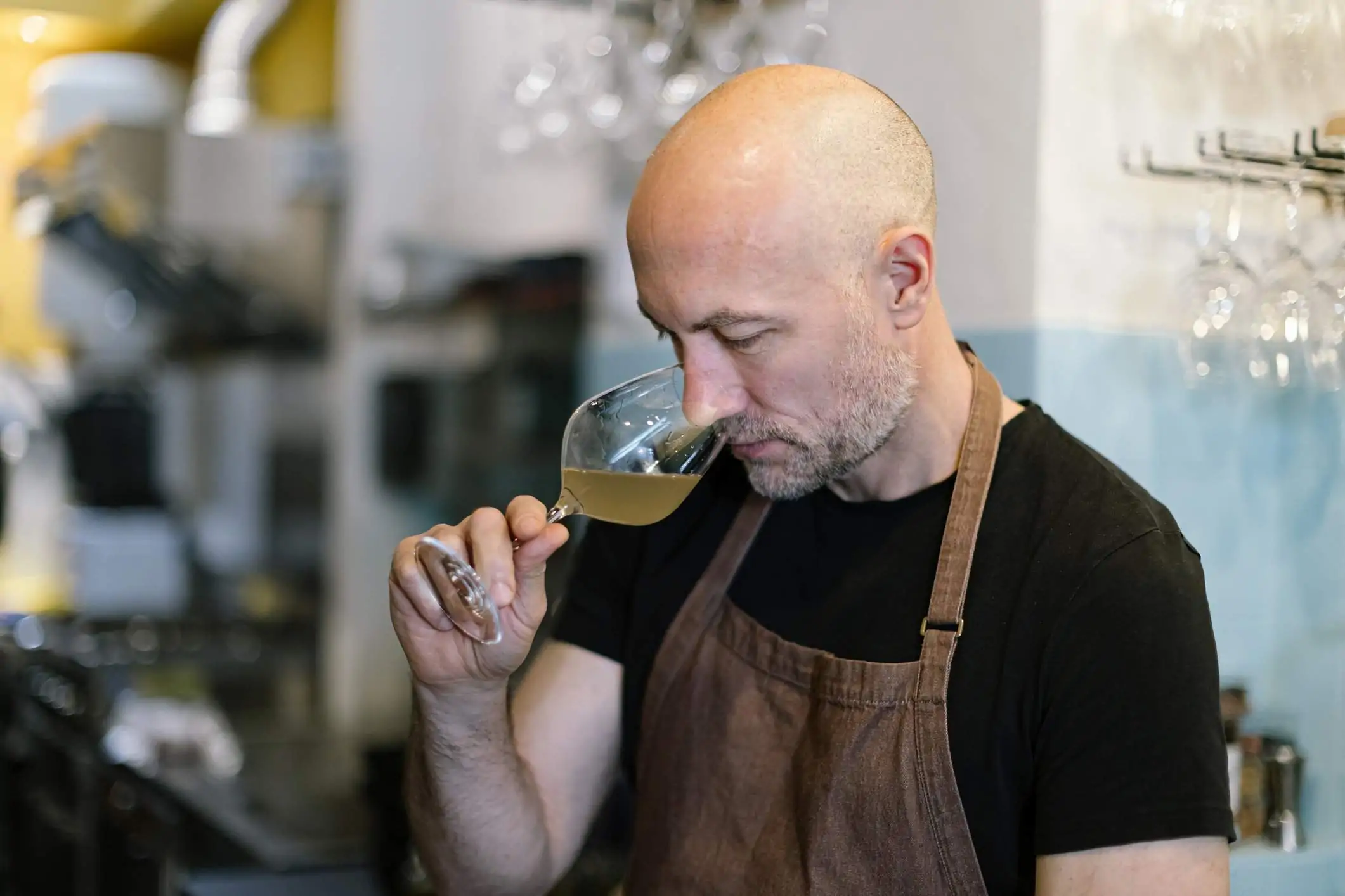 La imagen muestra a un sommelier catando una copa de vino.